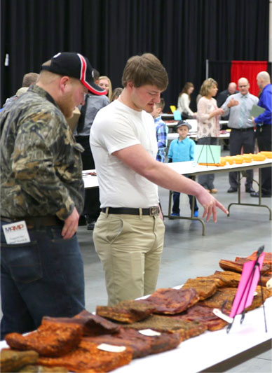 Convention participants inspecting items laid out on a white table